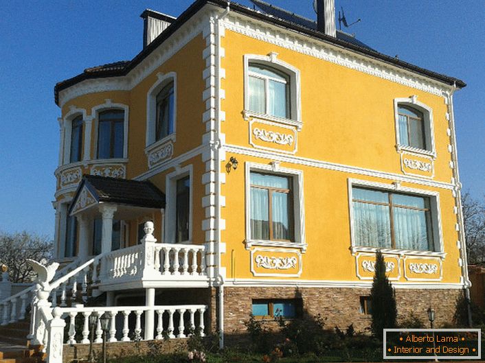 Фасадата на сградата е украсена с циментова замазка. Успешен вариант на декорация за имение в страната.