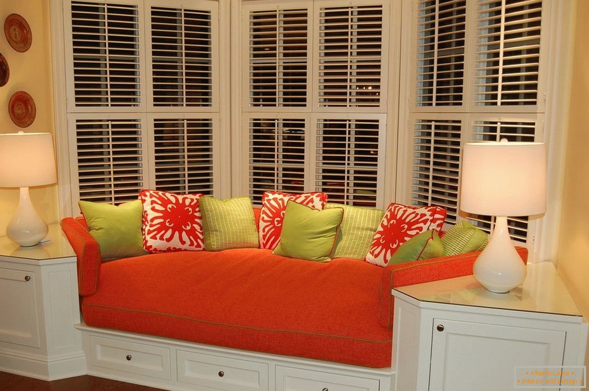 Червен диван с цветни възглавници