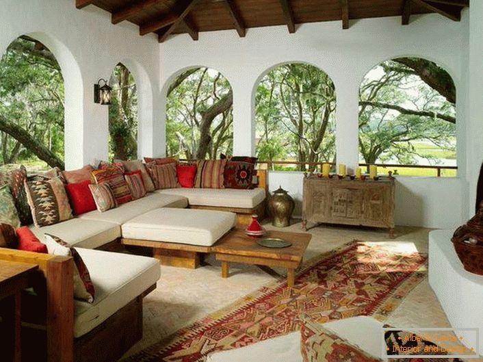 Верандата на селската къща е декорирана в съответствие със средиземноморския стил. Интересна особеност е интериорът с много цветни възглавнички.