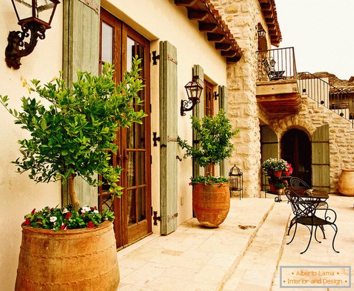 В двора в средиземноморском стиле украшают горшки с живыми растениями. Привлекательный дизайн, мебель с витиеватыми спинками, керамические горшки создают уютную, расслабляющую атмосферу. 