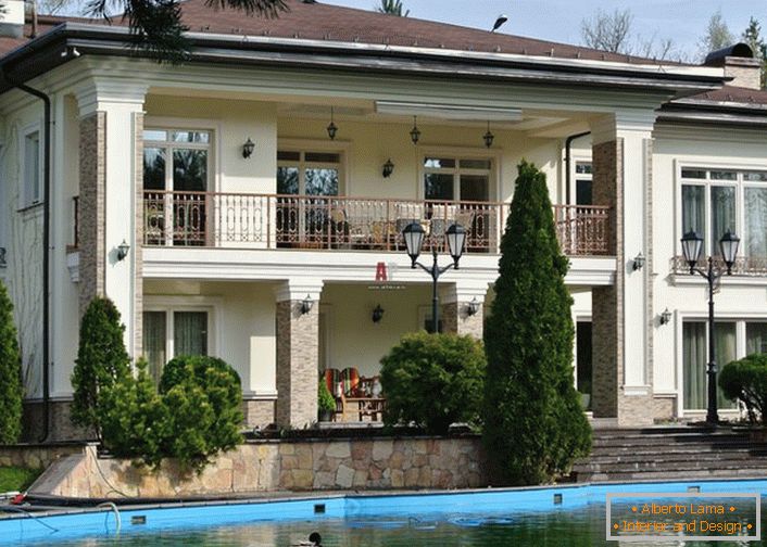 Дворът на къщата в средиземноморски стил е украсен с изкуствено езерце. Перфектен дизайн на крайградските зони. 