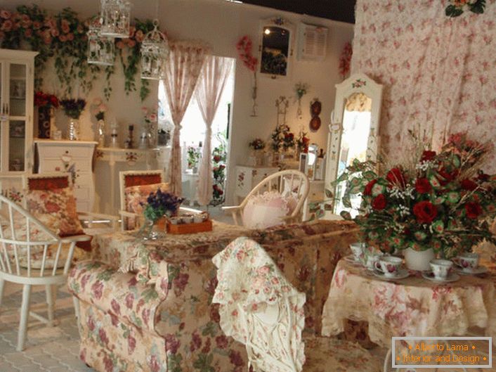 Цветя във вазата, на стената и дори на тапицерията на дивана. Зала в стила на Прованс в малка селска къща в южната част на Франция.
