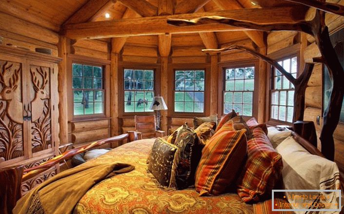 Една от спалните в къщата край езерото е направена в стила на селската страна. Дървена декорация. Масивните мебели и интериорни елементи се избират в най-добрите традиции на стил.