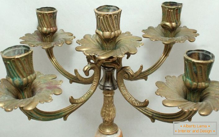 Стилният свещ, изработен от мед с хармонични мотиви на флора, е написан в интериора в стила на страната.