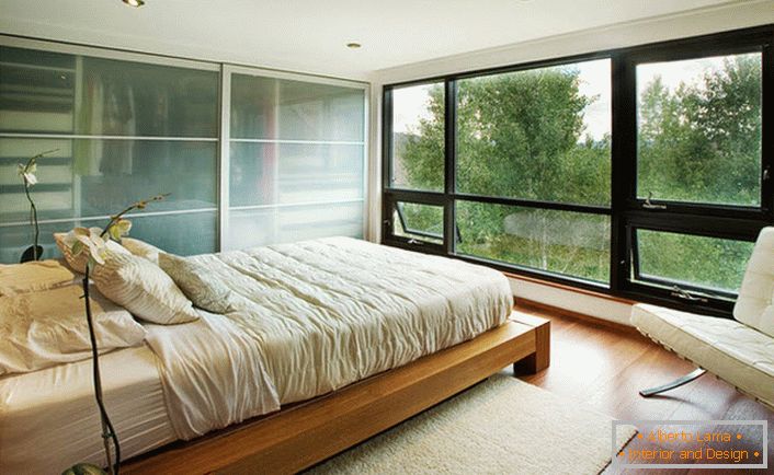 Едно ниско легло, изработено от дърво, хармонично се вписва във вътрешността на спалнята в стила на Арт Нуво.