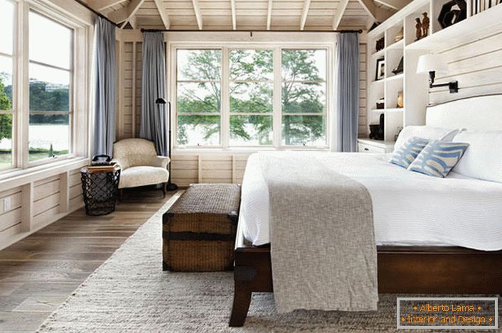 Спалня в скандинавски стил с голямо двойно легло, изработено от дърво в къщата на френски бизнесмен.