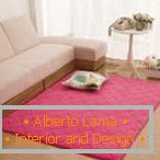 Розов килим в близост до бял диван