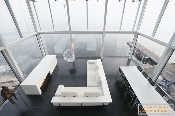 Лаконски дизайн на всекидневната в минималистичен стил. Интересна мебел е столът, окачен от висок таван.