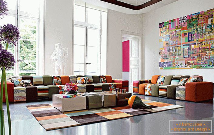 Колоритна стая за гости в авангарден стил в голяма къща на италианско семейство. Идеята за дизайн съчетава компетентно покритие от килими и мебели с приблизително еднаква цветова гама.
