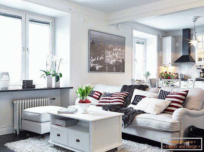 Уютният студиен апартамент в скандинавски стил е декориран главно в бяло. Прозорците без завеси позволяват достатъчно дневна светлина да влязат в стаята.