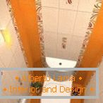 Комбинацията от бели и оранжеви плочки в дизайна на тоалетната