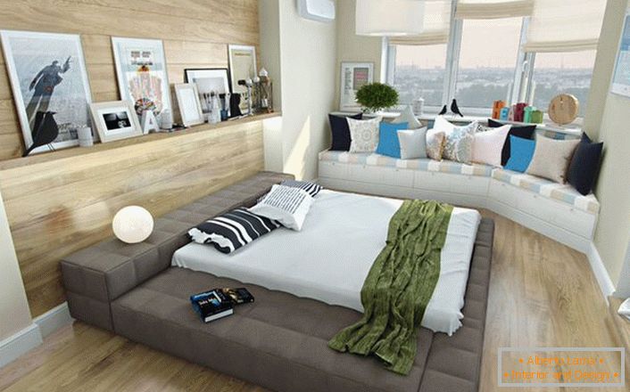 Интересно решение за спалня в скандинавски стил е малката дивана под прозореца, украсена със светли възглавници. 