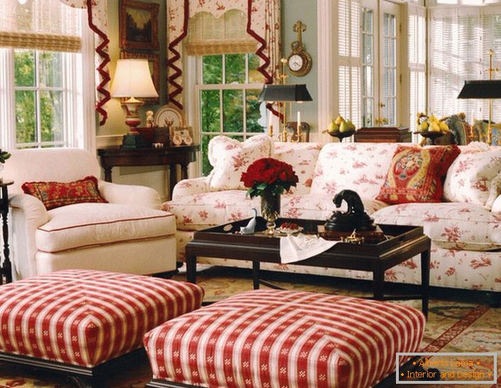 Проста, скромна и уютна всекидневна в английски стил в малка селска къща. Акцентите на червено правят атмосферата в стаята спокойна и весела.