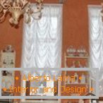 Комбинацията от бели завеси и оранжеви стени