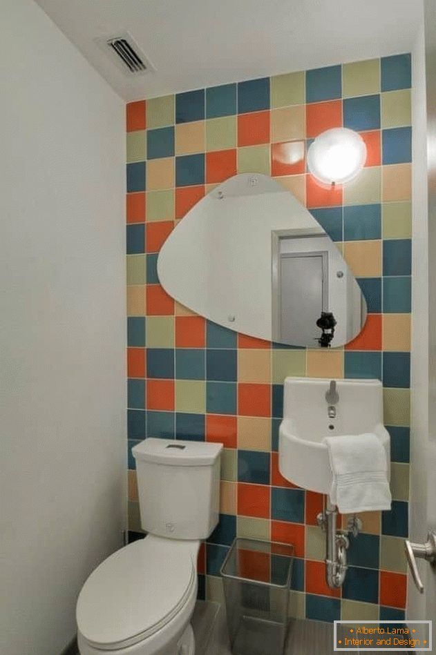 Малка тоалетна със светли плочки и боядисани стени