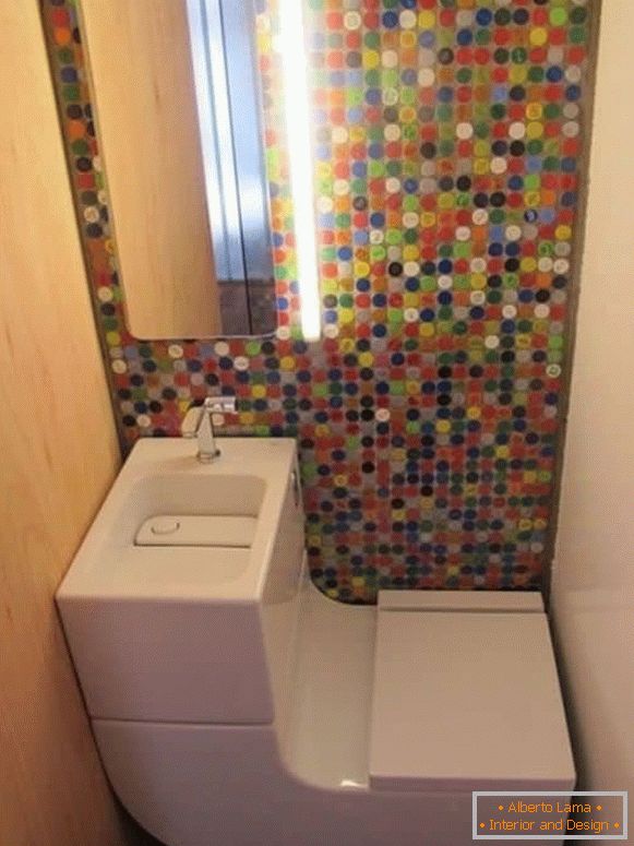 Малка тоалетна с модерна комбинирана тоалетна и светла мозайка