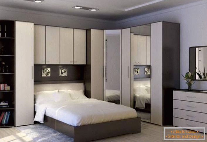 Функционална ъглова стена за спалнята. Правилно проектираното пространство остава просторно и не претрупано. Място за спасяване позволяват шарнирни шкафове над леглото.
