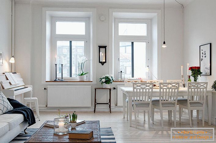 Стилната всекидневна е разделена на кът за сядане и трапезария. Съгласно скандинавския стил стените на стаята са декорирани в бяло.