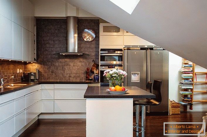 Кухнята на тавана е декорирана в скандинавски стил. Бялата кухненска маса изглежда добре на фона на стените на тъмните тухли. 