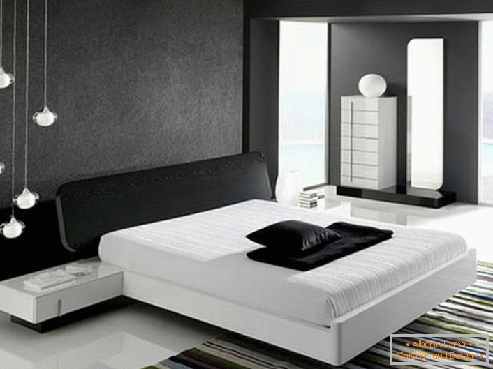 Стената в главата на леглото, украсена със сива матова вложка, в съответствие със стила на хай-тек, е в хармония с лъскавия бял под.