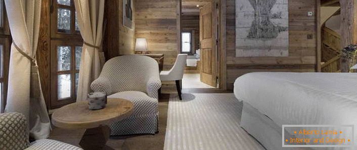 В спалнята в стила на алпийската хижа има легло, което прилича на легло с лек перо.