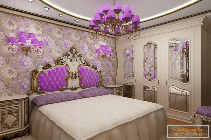 Елегантна барокова спалня с интересен акцент върху осветлението. Полилеи и лампи за нощни лампи със същите виолетови нюанси, хармонично съчетани с тапицерията на облегалката в главата на леглото.