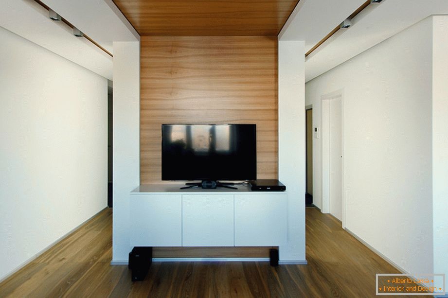 Голям черен телевизор на бяла маса в хола