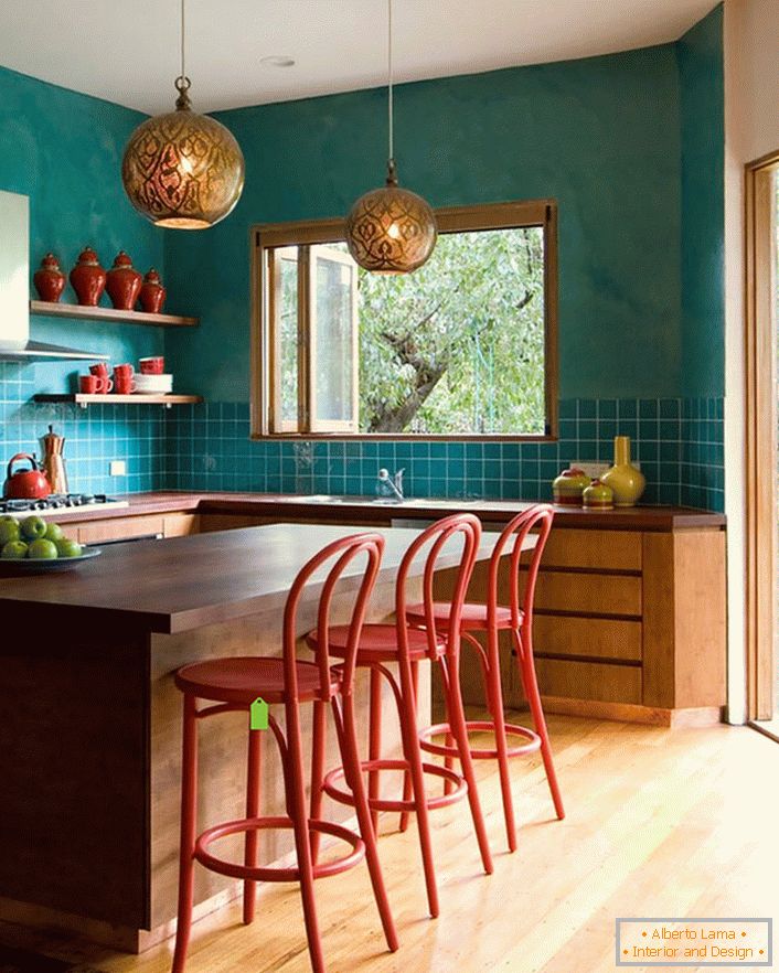 Тюркоазната декорация на стената в кухнята прави стаята по-просторна. Лаконичните, скромни мебели се вписват безпроблемно в цялостния интериор в стил на еклектизъм.
